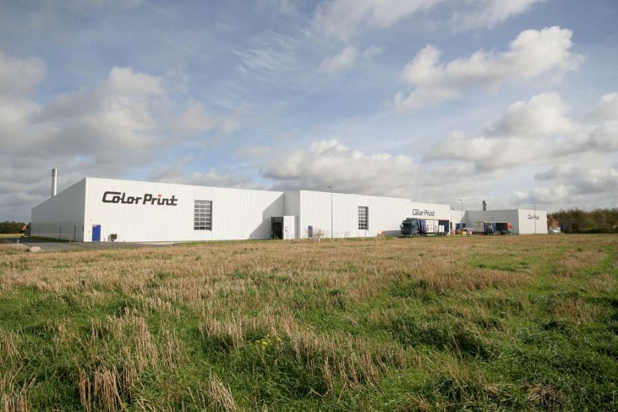 Der Firmenname strahlt auf der weißen Fassade